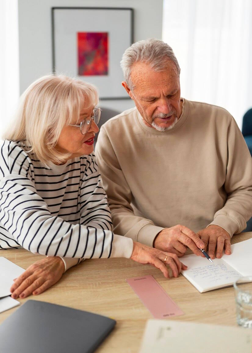Ein Ehepaar sitzt am Tisch und ist in Unterlagen vertieft. Sie informieren sich über die verschiedenen Modelle der betrieblichen Altersvorsorge
