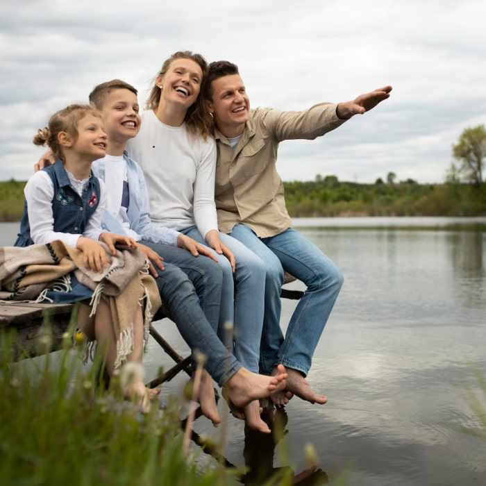 Foto zeigt glückliche Familie an einem See. Das steht als Sinnbild für die Sicherheit durch die Riester Rente